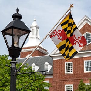 Maryland flag in front of historic brick building.